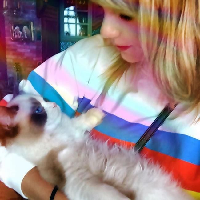 Taylor Swift posando con uno de sus gatos