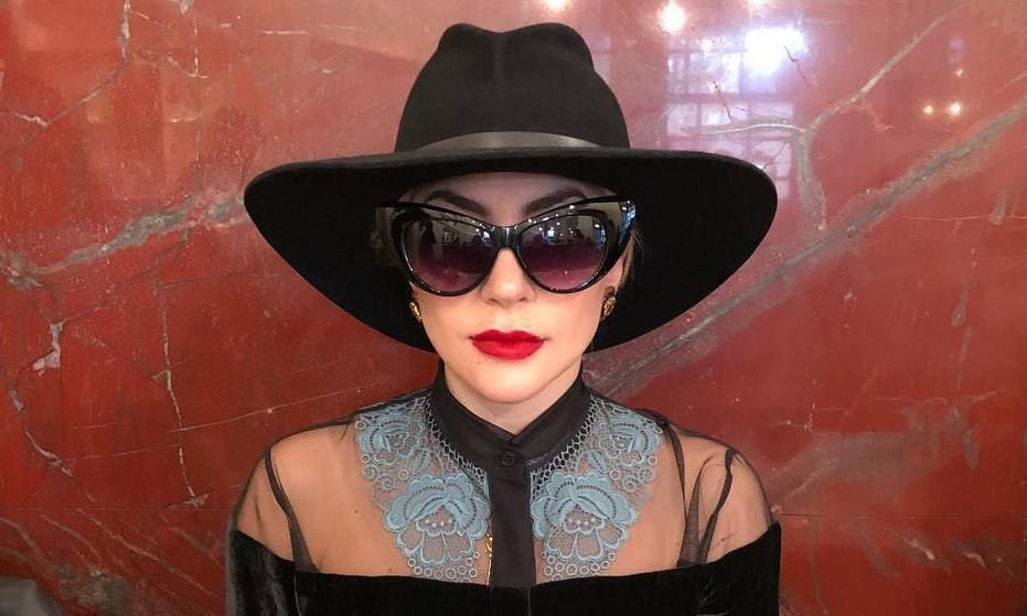 Lady Gaga con red lipstick sombrero y lentes de sol