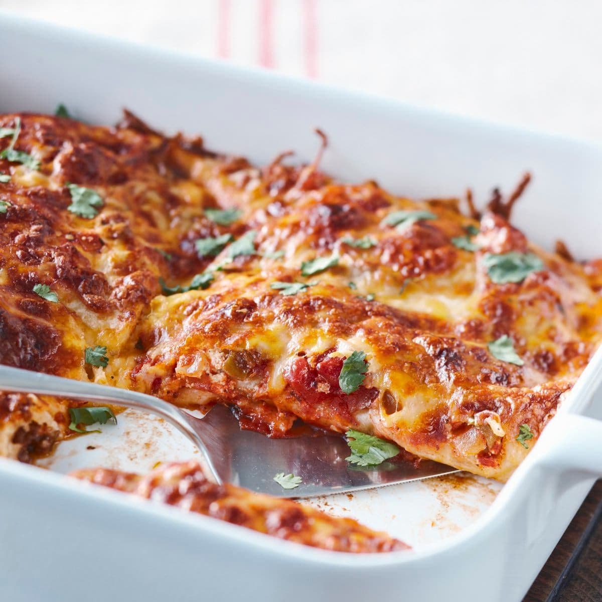 Enchiladas with beef, tomato sauce, cheese and coriander