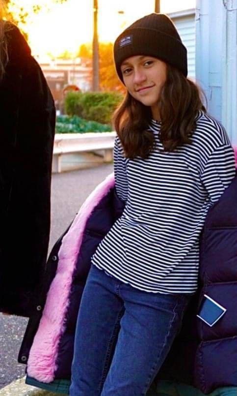 Emme Muniz wearing a striped shirt looking just like her mom.