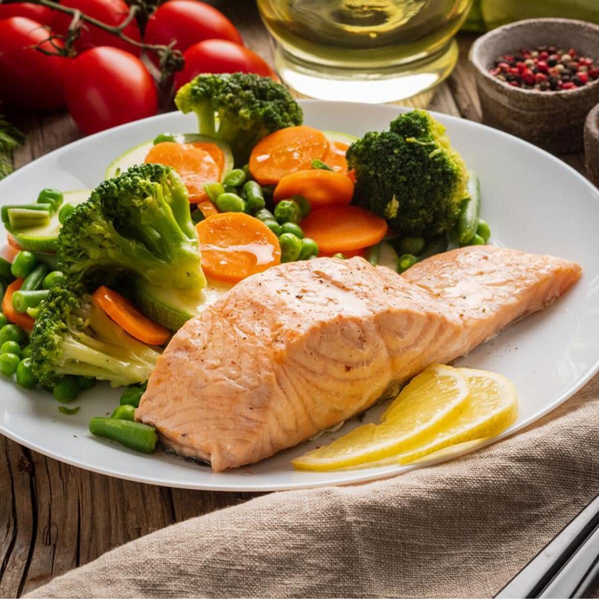 Plato con brocoli, salmon, zanahorias y rodajas de naranjas