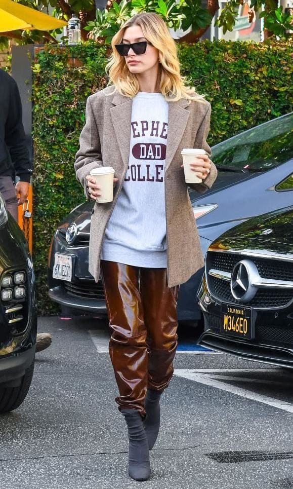 Hailey Baldwin in patent brown leather pants and an oversize jacket