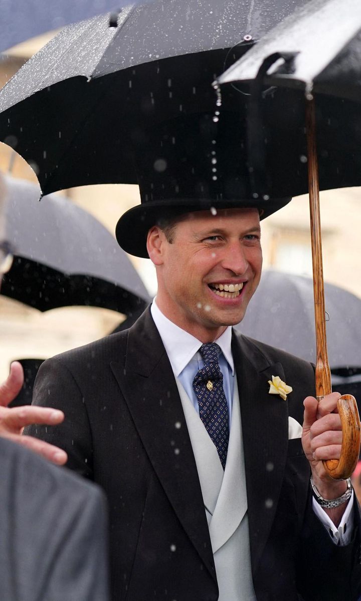 Despite the rain, Prince William was all smiles while meeting guests at the garden party in London.