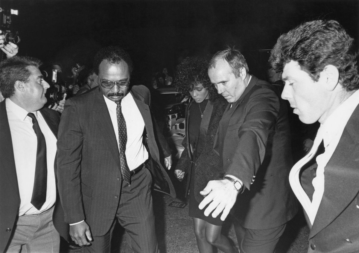 Bodyguards escort American singer Whitney Houston (1963 - 2012) into a party she is throwing in London, 16th May 1988. (Photo by Dave Hogan/Getty Images)