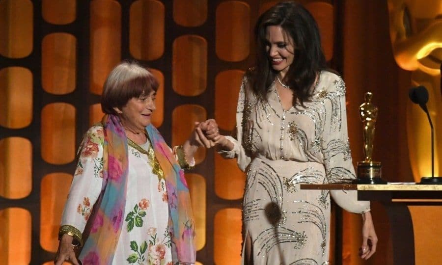 Dance revolution! During a heartfelt speech, Angelina Jolie praised French director Agnes Varda, who was an honoree at the 2017 Governors Awards. While the star may have expected a hug from Agnes afterwards, she probably didn't ever think they'd do a dance! However, that's exactly what they did. The 89-year-old Varda talent broke out her moves after accepting the honorary Oscar in what was a highlight of the evening. "Tonight. I feel like dancing," Varda said to the crowd. "The dance of cinema." Angelina, who lived up to her stylish reputation in a bedazzled beige Elisabetta Franchi dress, was game for the impromptu moment, smiling as the pair got jiggy with it.
Photo: Getty Images