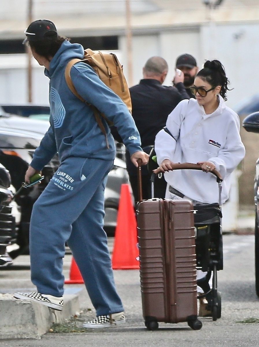 Vanessa Hudgens and her husband, Cole Tucker, accompanied by their baby in a stroller and dog. 