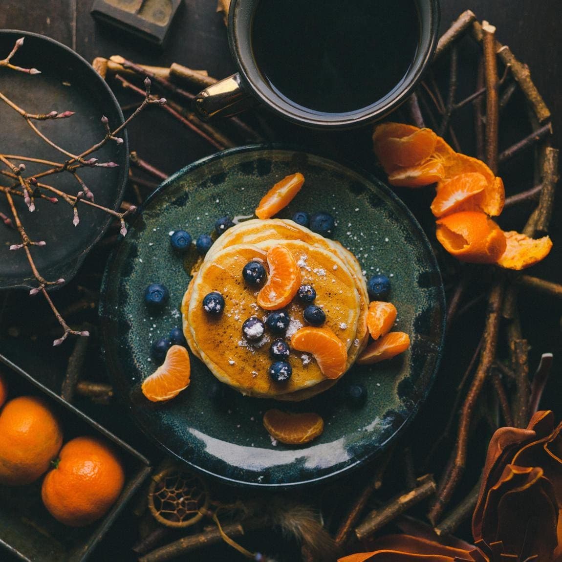 Plate of healthy pancakes with blueberries and tangerine