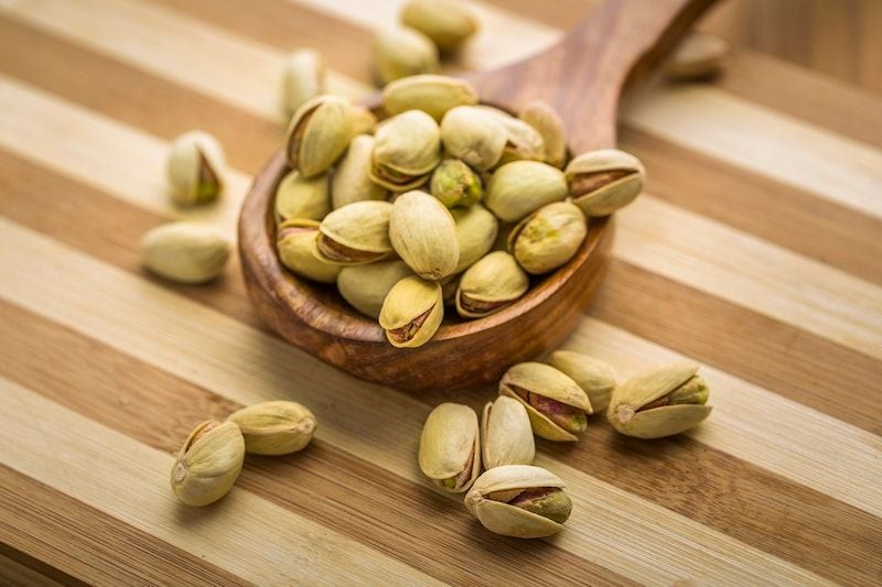 Pistachios in a wooden spoon