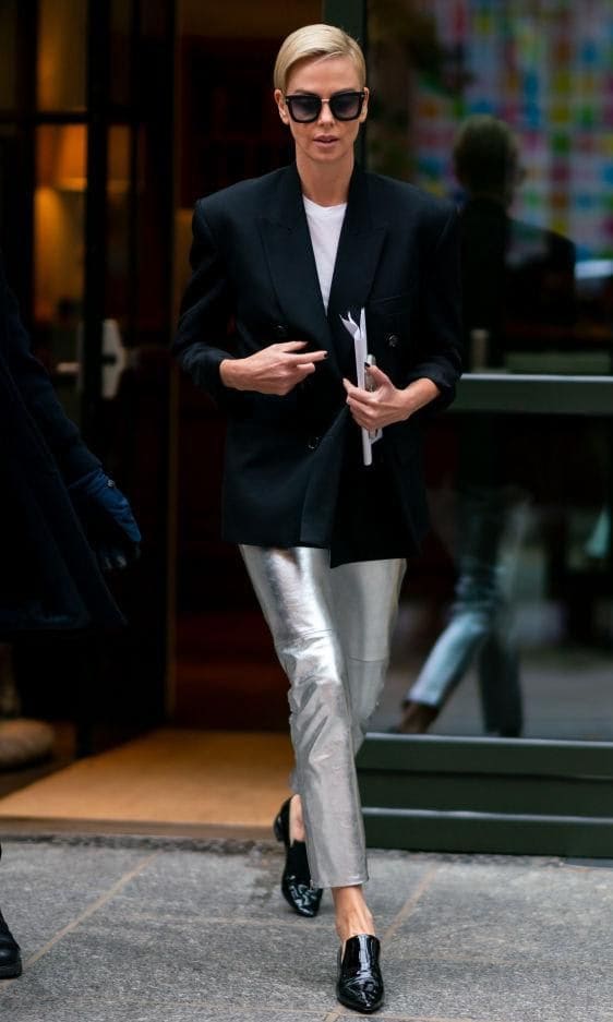 Charlize Theron with black patent leather loafers and metallic pants