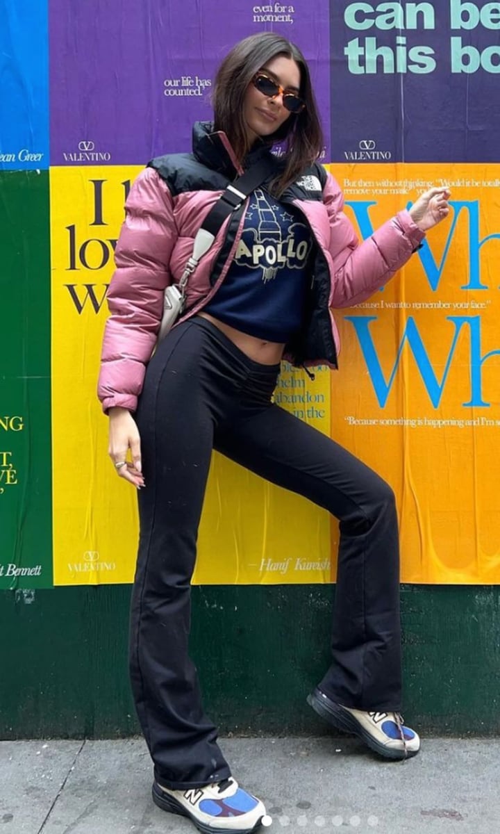 Emily Ratajkowski wearing a North Face puffer jacket and Y2K flared leggings