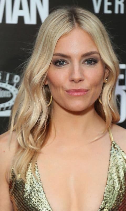 Sienna Miller con melena rubia y vestido dorado