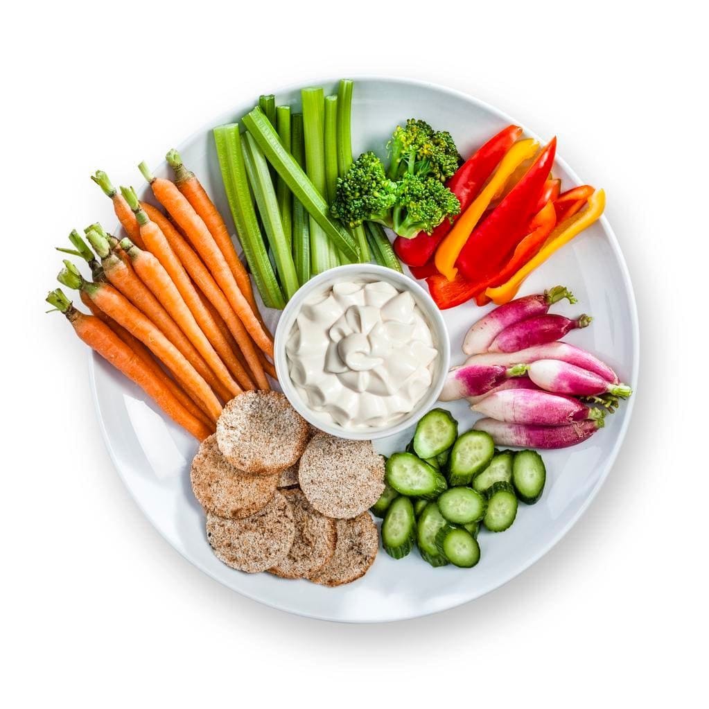 A plate of raw veggies with hummus