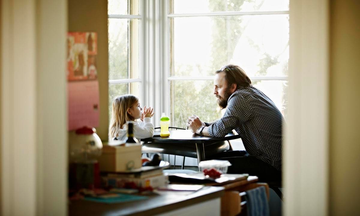 Father and daughter sitting at table in discussion