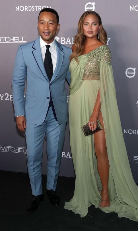 John Legend in a light blue suit and Chrissy Teigen in a light pastel green gown