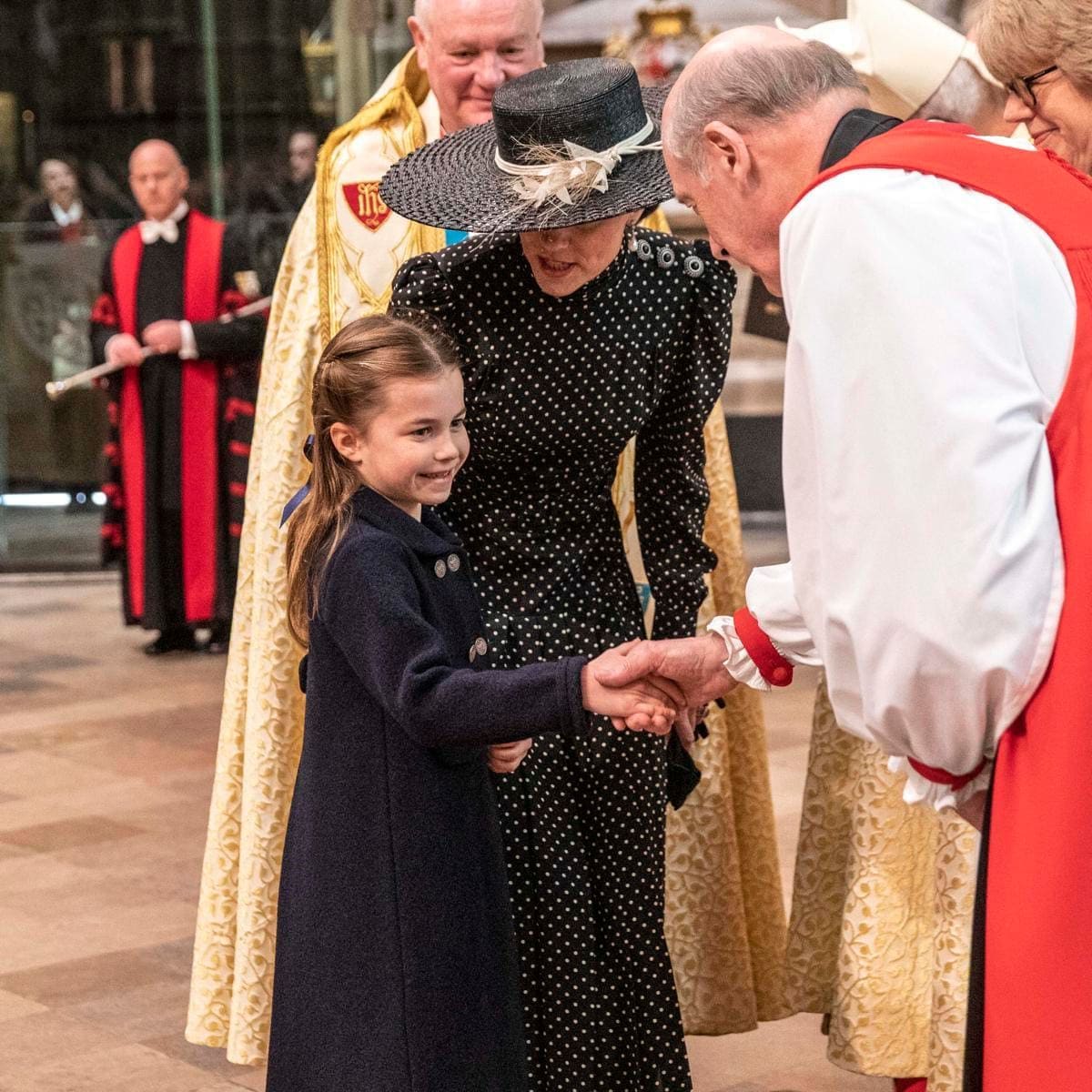 The polite little Princess shook hands with clergymen at the service.