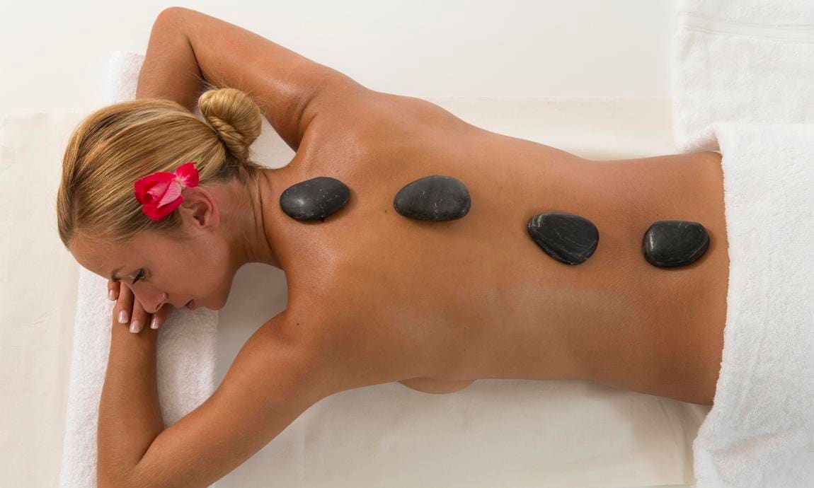 Woman having hot stone massage therapy