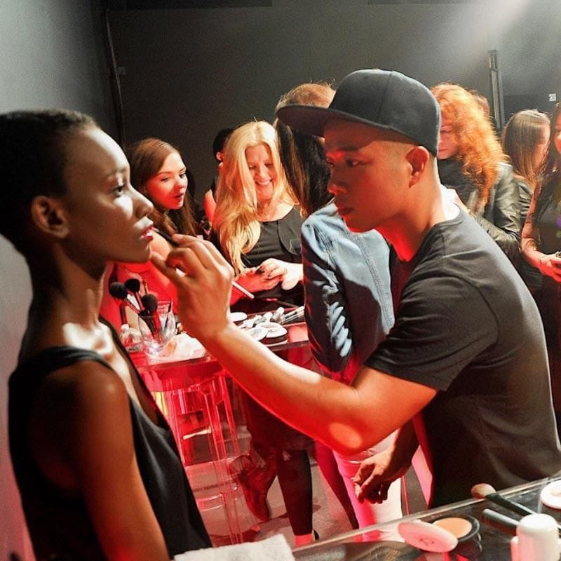 Hung Vanngo putting makeup on a model