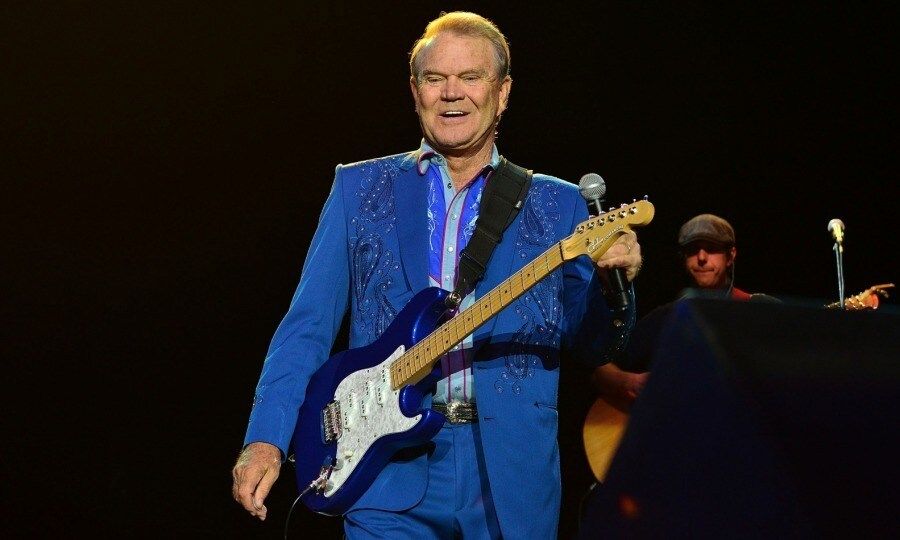 <b>Glen Campbell - August 8</b>
Legendary country singer and guitarist Glen Campbell died at the age of 81 after a long and courageous battle with Alzheimer's.
His family confirmed the saw news with a statement on the talent's official website. Glen passed away in a Nashville facility on Tuesday, August 8. His diagnosis was documented in the 2014 documentary <i>I'll Be Me</i>, which also highlighted his farewell tour.
During his decades-long career, Glen released over 70 albums, sold over 45 million records, was inducted into the Country Music Hall of Fame and won 10 Grammy Awards, among various achievements. He also notably won the CMA's "Entertainer of the Year award" in 1968. Some of his greatest hits include: "Gentle on My Mind," "Wichita Lineman," "Galveston," "Country Boy," and "Rhinestone Cowboy."
He is survived by: his wife, Kim Campbell and their three children (Cal, Shannon and Ashley), his children from previous marriages (Debby, Kelli, Travis, Kane, and Dillon), ten grandchildren, great and great-great-grandchildren, sisters (Barbara, Sandra, and Jane) and brothers (John Wallace "Shorty" and Gerald).
Photo: Lisa Lake/Getty Images