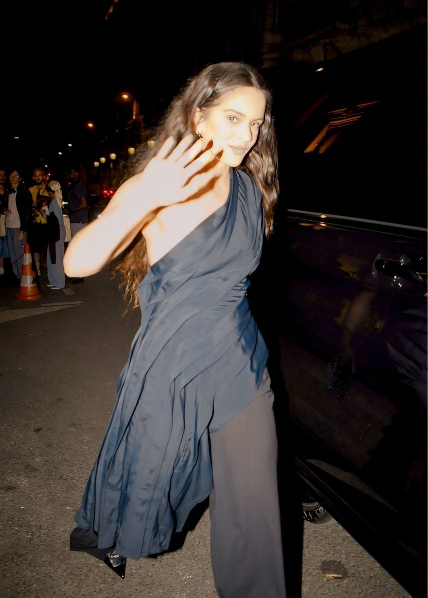 Singer Rosalia stuns in a shoulder-less black dress as she warmly greets fans after a Dior party in Paris.
