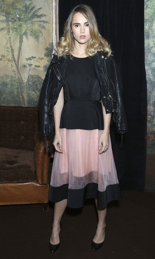 Model Suki Waterhouse hardens up her ladylike pink dress with a jacket draped stylishly over her shoulders.
<br>
Photo: Getty Images