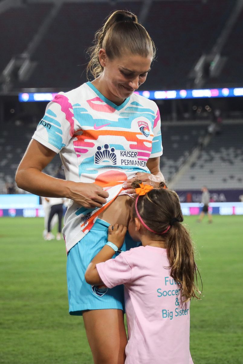 SAN DIEGO, CALIFORNIA - SEPTEMBER 08: Alex Morgan #13 of San Diego Wave FC interacts with her daughter, Charlie, after the game against North Carolina Courage at Snapdragon Stadium on September 08, 2024 in San Diego, California. Morgan bid farewell to fans and fellow athletes after announcing her retirement from the game three days earlier, marking this game as her last. (Photo by Meg Oliphant/Getty Images)