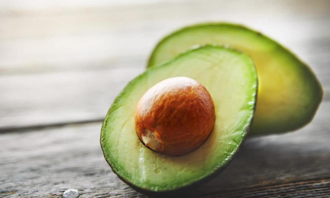 Avocado halves on a wooden table