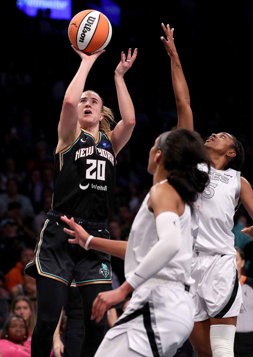 NEW YORK, NEW YORK - OCTOBER 01: Sabrina Ionescu #20 of the New York Liberty heads for the net as A'ja Wilson #22 and nn15 defend in the second half of Game Two of the WNBA Semifinals at Barclays Center on October 01, 2024 in New York City. The New York Liberty defeated the Las Vegas Aces 88-84. NOTE TO USER: User expressly acknowledges and agrees that, by downloading and or using this photograph, User is consenting to the terms and conditions of the Getty Images License Agreement. (Photo by Elsa/Getty Images)