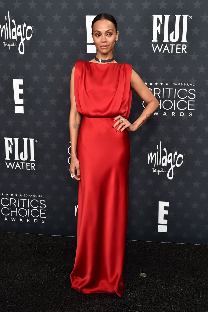 Zoe Saldaña stuns in a sleek red gown at the 2025 Critics Choice Awards red carpet.