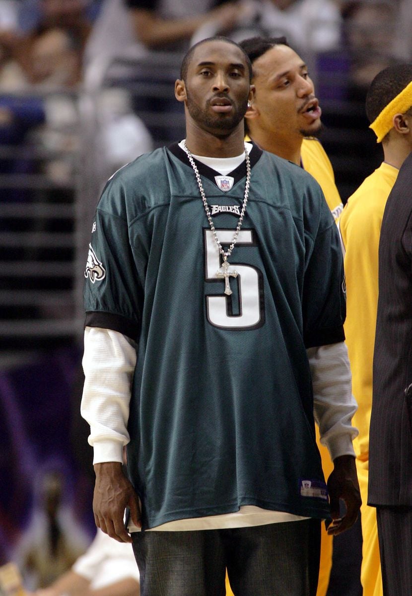 LOS ANGELES - FEBRUARY 3:  Injured guard Kobe Bryant of the Los Angeles Lakers wears an NFL jersey of quarterback Donovan McNabb of the Philadelphia Eagles during a game against the San Antonio Spurs on February 3, 2005 at Staples Center in Los Angeles, California. McNabb will play in the Super Bowl on Sunday.  NOTE TO USER: User expressly acknowledges and agrees that, by downloading and or using this photograph, User is consenting to the terms and conditions of the Getty Images License Agreement.  (Photo by Stephen Dunn/Getty Images)