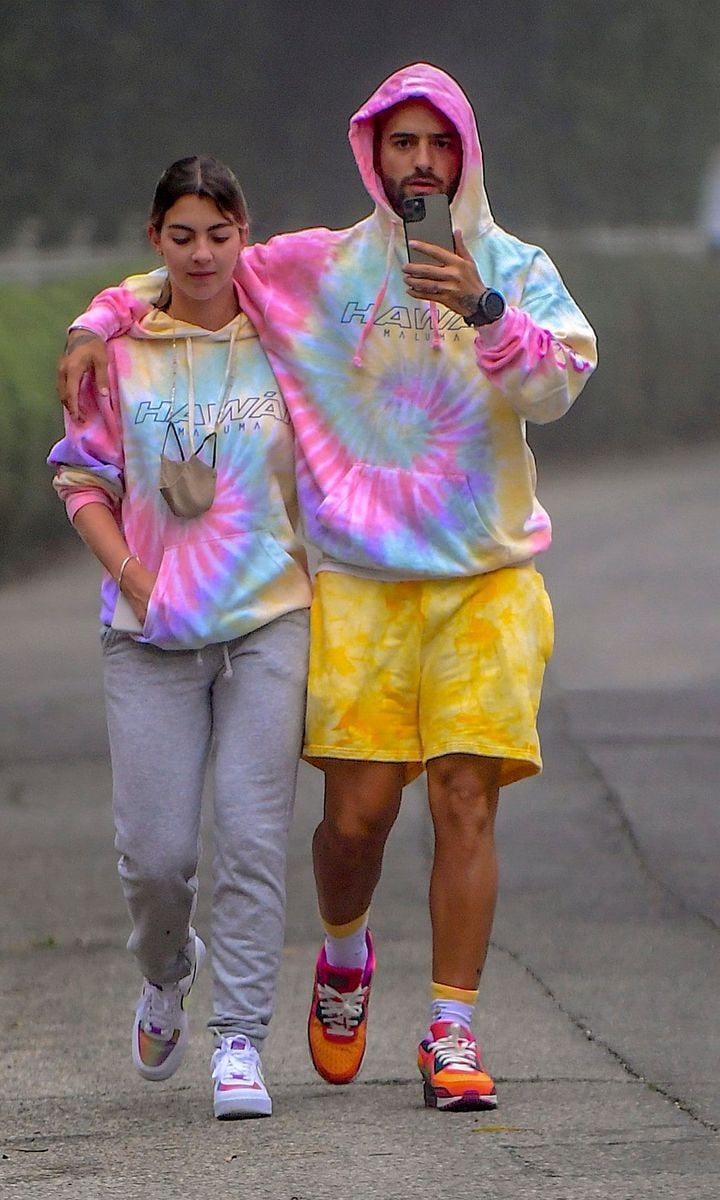 Colombian Superstar, Maluma, was spotted out in Beverly Hills on Sunday morning, enjoyed a loved up stroll with rumored new girlfriend, Susana Gomez. The couple walked arm in arm while wearing matching Maluma "Hawai" Tie Dye Hoodies. They put their arms around each other while taking a cute selfie one their way to breakfast.