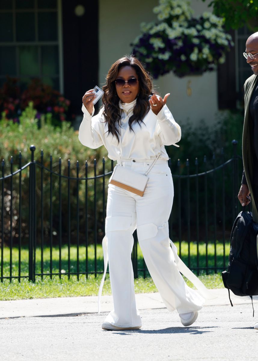 Oprah Winfrey holds her name tag after leaving the morning session with Van Jones looking on at the Allen & Company Sun Valley Conference on July 10, 2024, in Sun Valley, Idaho. The annual gathering organized by the investment firm Allen & Co brings together the world's most wealthy and influential figures from the media, finance, technology, and political spheres at the Sun Valley Resort for the exclusive weeklong conference. 