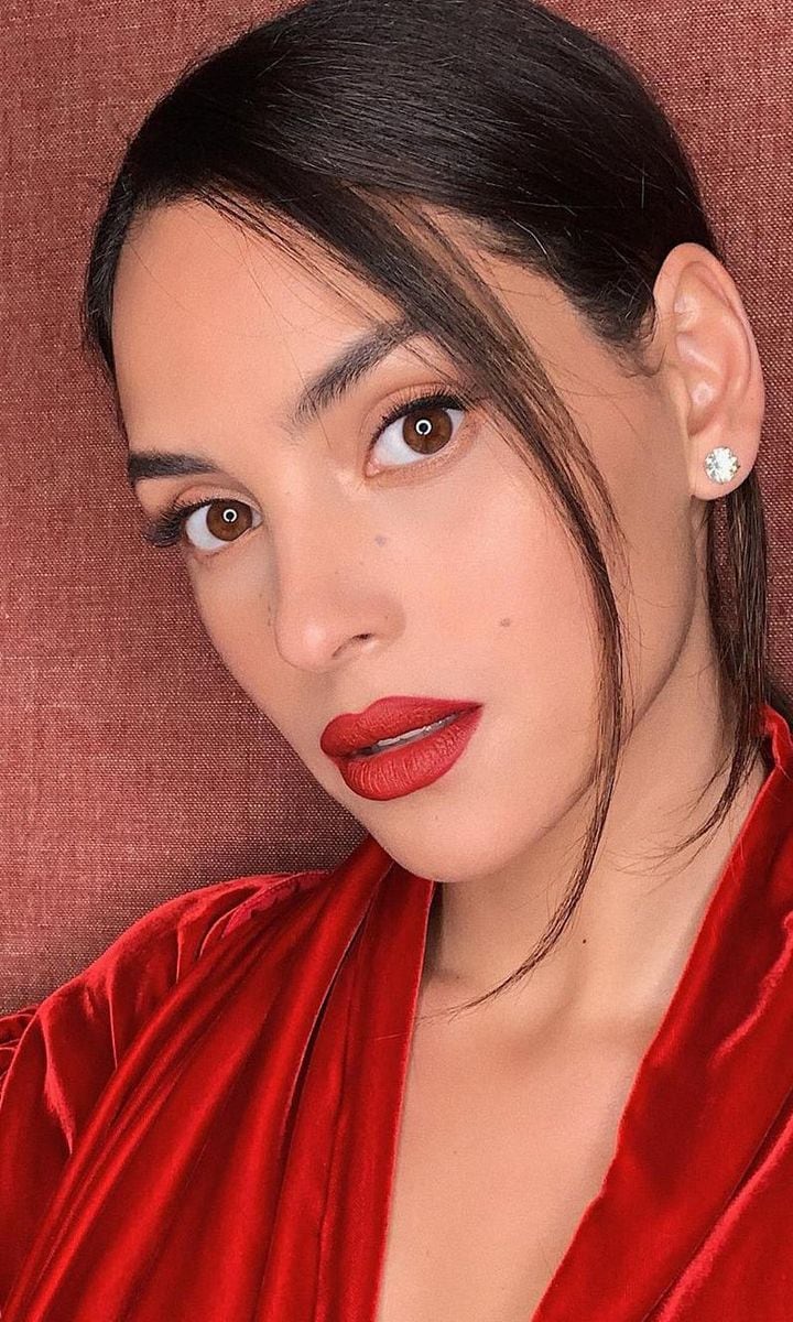 Adria Arjona with makeup featuring red lips and her hair up