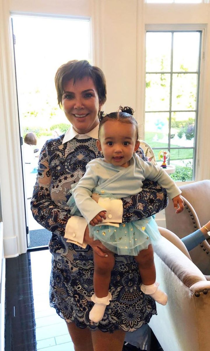 Kris Jenner, smiling. carrying Chicago West.