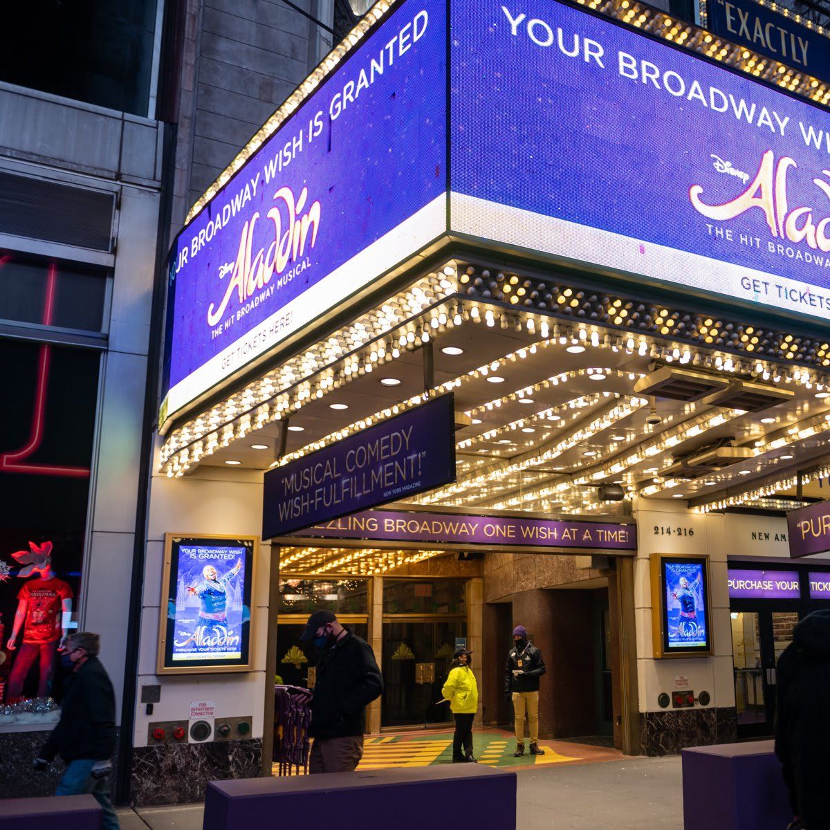 People walk past the New Amsterdam Theatre home to “Aladdin” which has postponed shows due to COVID 19 outbreaks on December 21, 2021 in New York City.