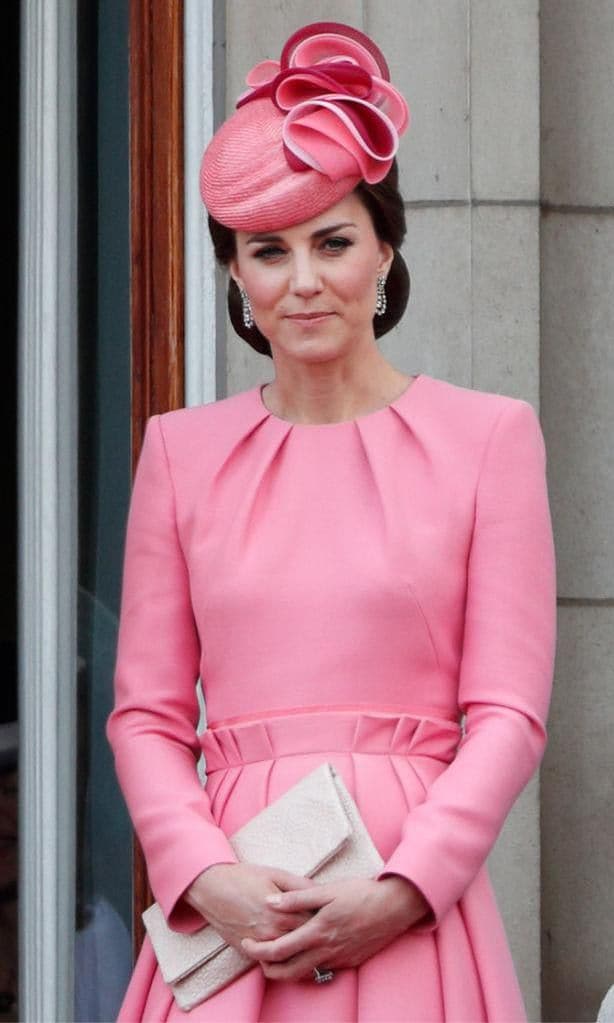 Kate Middleton wearing a pink coat dress and fascinator