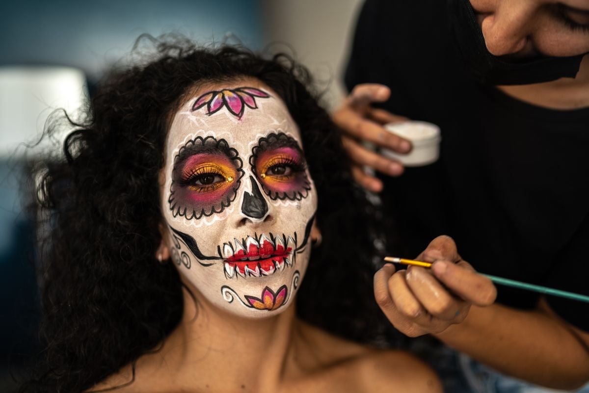 Young woman having her makeup done for day of the dead