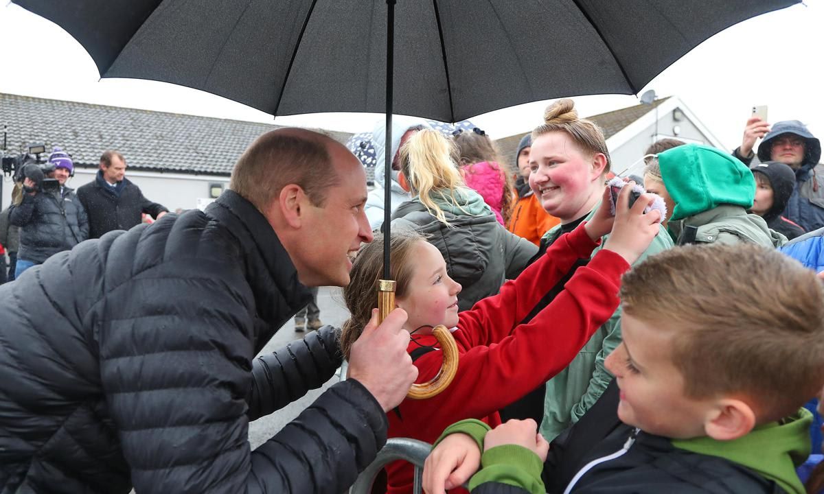 The heir to the throne happily posed for a selfie with a young well-wisher outside of the Dowlais Rugby Club.