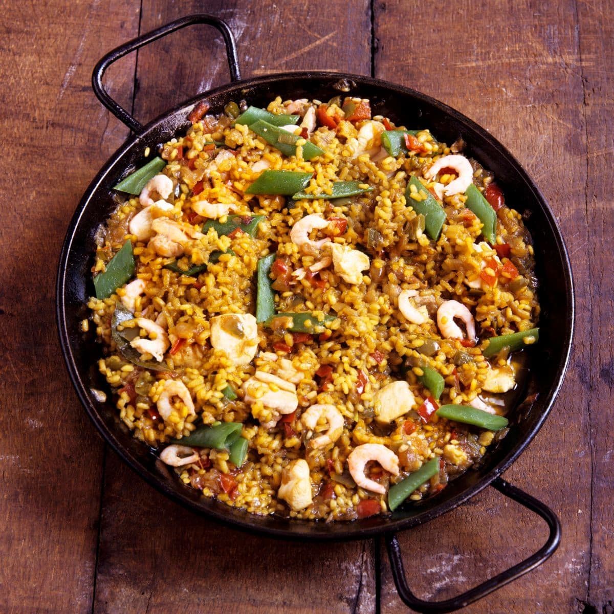 Paella with chicken and shrimps in pan