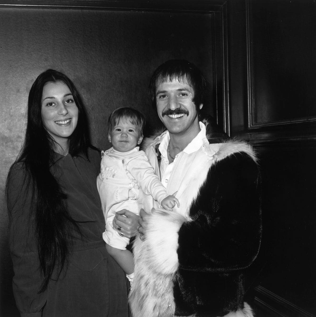 1970:  Married American singing duo Sonny (1935 - 1998) and Cher smiling and holding their infant daughter Chastity at Zsa Zsa Gabor's opening at 'The Flamingo,' Las Vegas, Nevada.  (Photo by Max B. Miller/Fotos International/Getty Images)