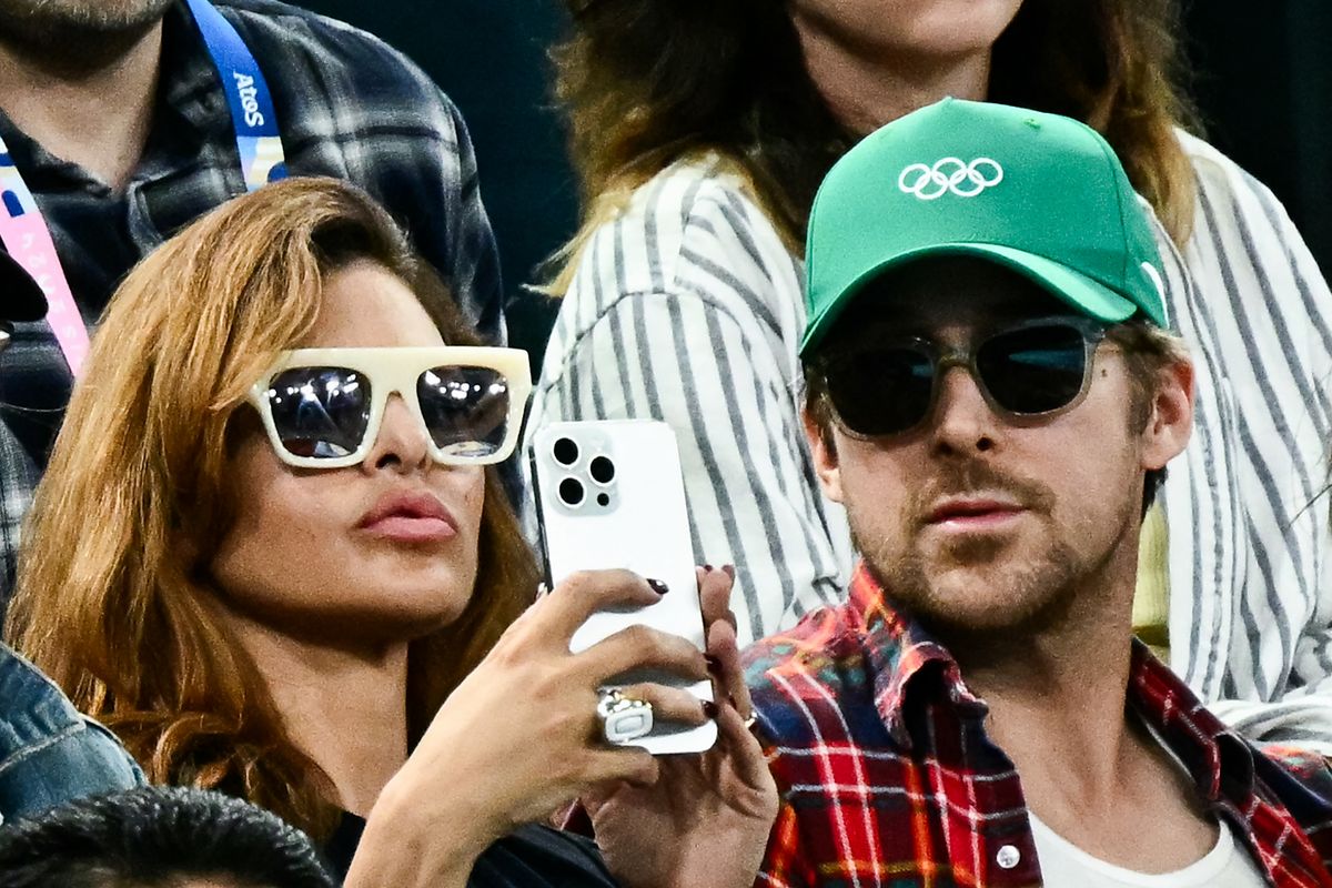 US actress Eva Mendes (L) and her partner, Canadian actor Ryan Gosling (R), attend the artistic gymnastics women's uneven bars final during the Paris 2024 Olympic Games at the Bercy Arena in Paris on August 4, 2024. (Photo by Loic VENANCE / AFP) (Photo by LOIC VENANCE/AFP via Getty Images)