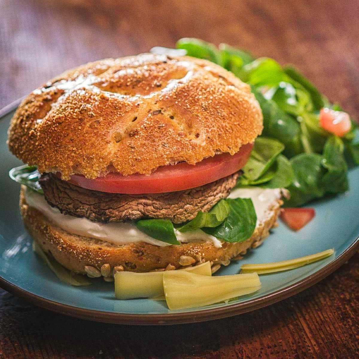 Delicious Portobello Mushroom Veggie Burger with avocado, tomato and fresh salad