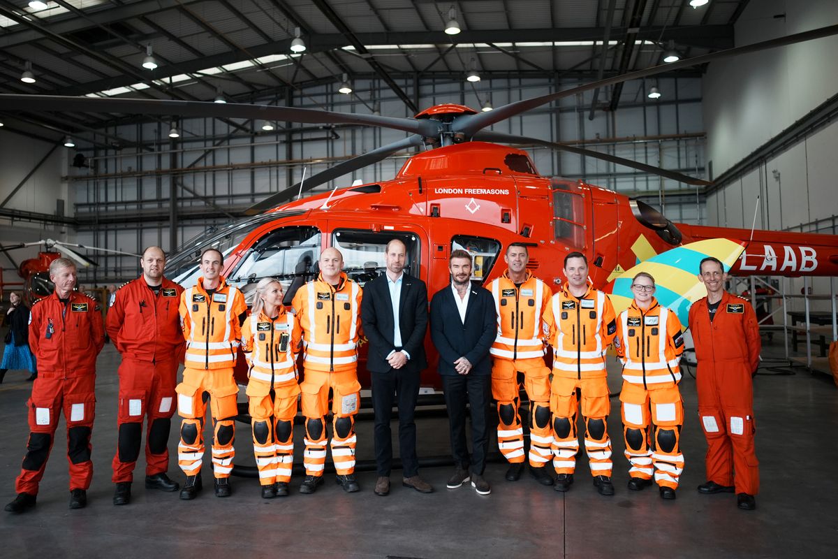 RUISLIP, ENGLAND - OCTOBER 1: Prince William, Prince of Wales (C-L) and David Beckham (C-R) pose for a photograph with members of the Air Ambulance crew during a visit to RAF Northolt to view the new London Air Ambulance Charity helicopters on October 1, 2024 in Ruislip, England. (Photo by Aaron Chown - WPA Pool/Getty Images)