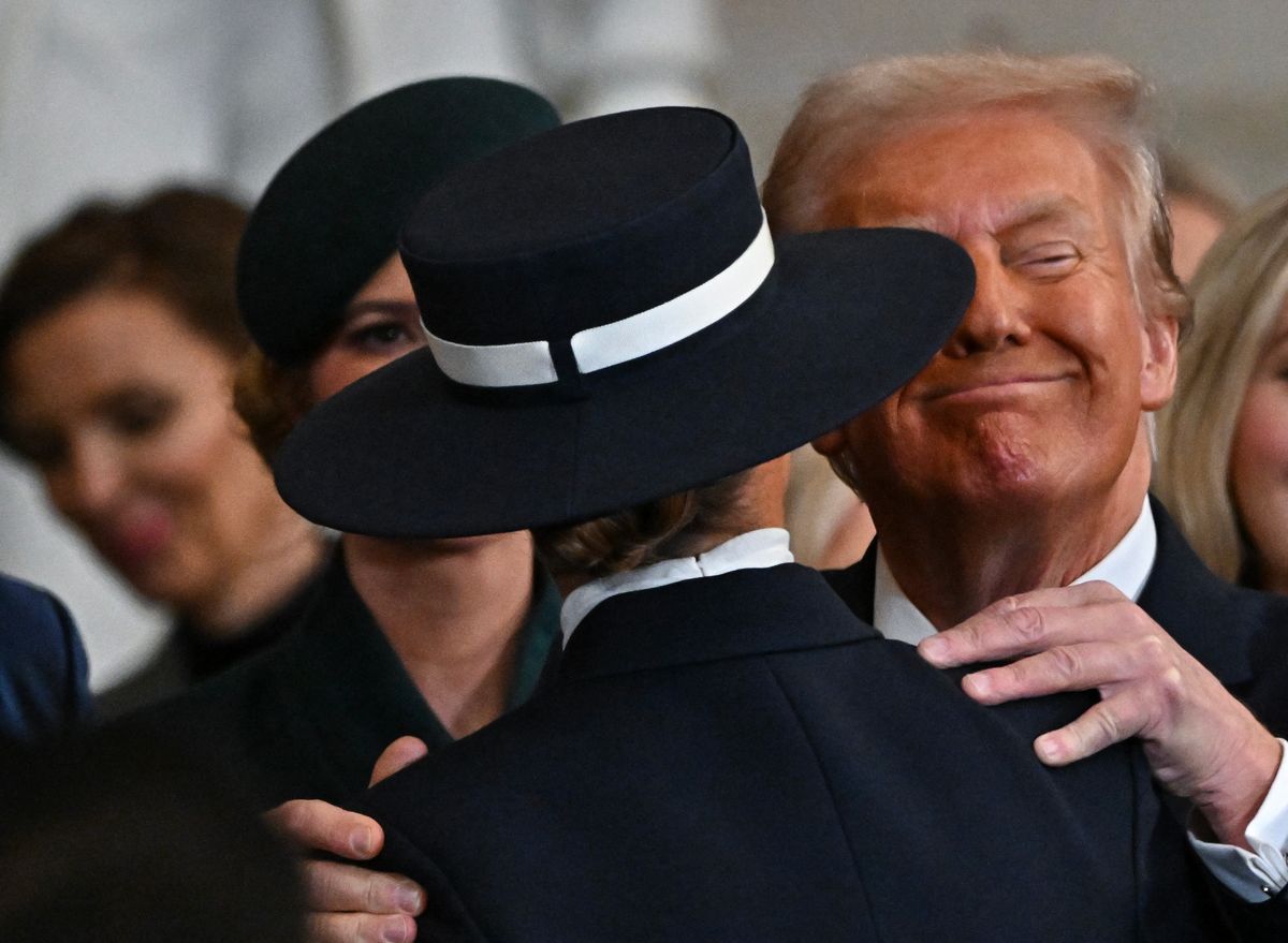 President Donald Trump smiles while kissing his wife and First Lady Melania Trump