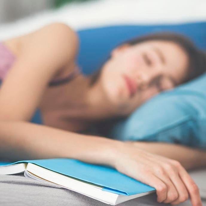 Woman sleeping while holding book