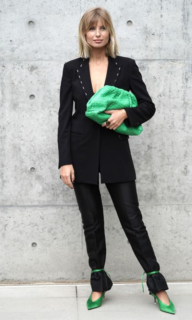 Xenia Adonts in a black blazer and black pants with green ankle strap sandals tied over the bottom of her pants