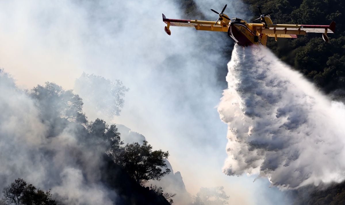 A firefighting aircraft drops water as the Franklin Fire continues to burn on December 10, 2024 near Malibu, California. 