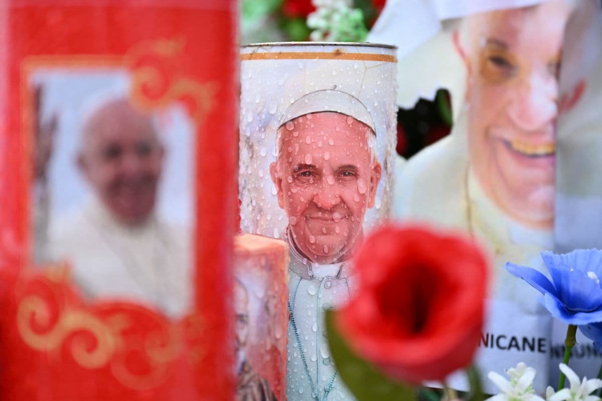 Candles and messages of healing for Pope Francis are laid at the statue of John Paul II outside the Gemelli hospital where the Pope is hospitalized