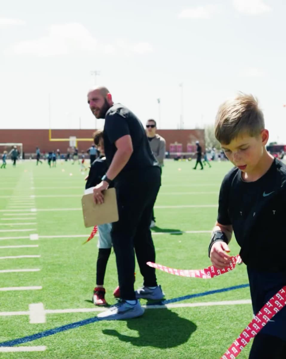 Theo is in action on the football field, showcasing his skills in a flag football game. With intense focus and swift movement, he is ready to make a play.