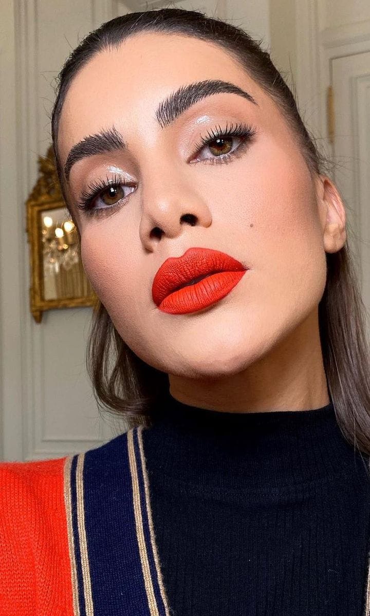 Camila Coelho in red lipstick with coral undertones
