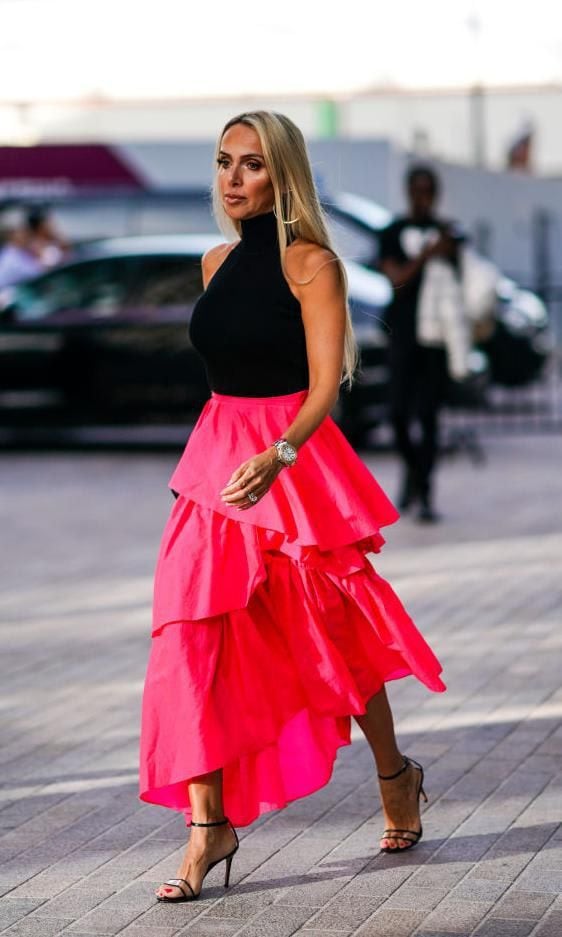 Full photo of woman walking with fuchsia layered skirt